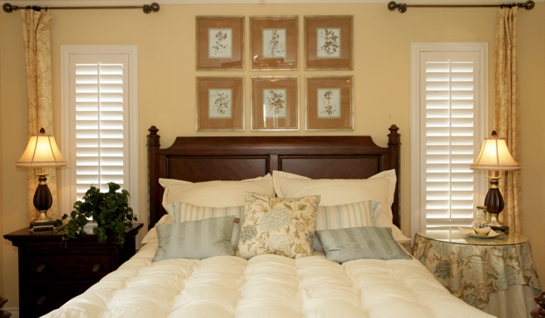 Beige bedroom with white plantation shutters covering windows in Las Vegas 